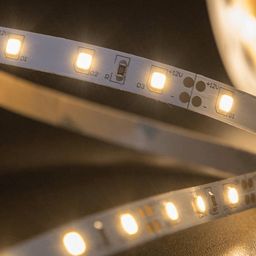 Қосылған күйдегі 12 В жылы ақ жарық беретін LED таспа, ірі план